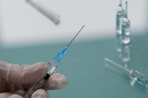 Doctor holding a syringe with a transparent injection. Close-up.