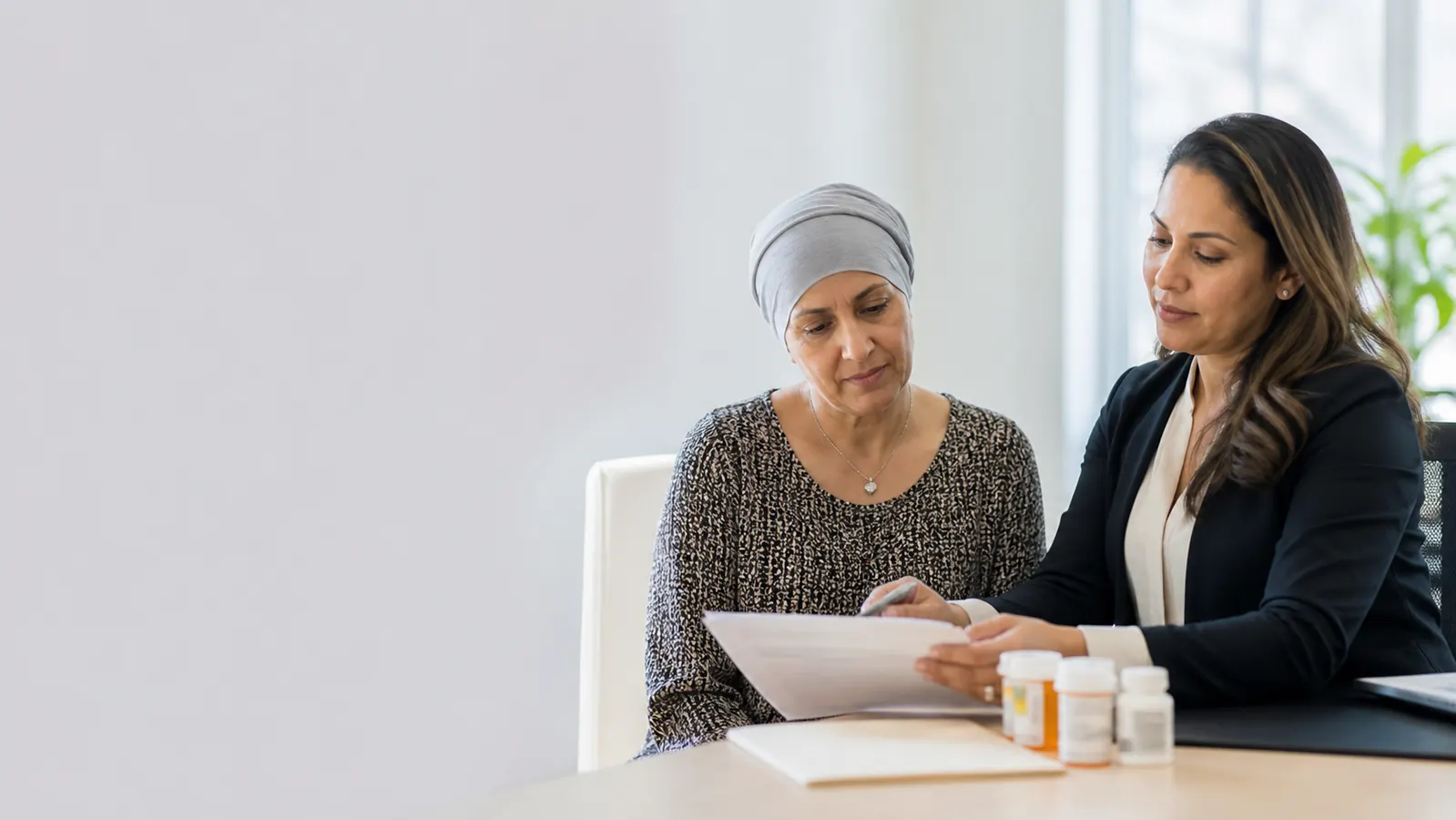 Cancer patient reviewing medication assistance paperwork with a navigator
