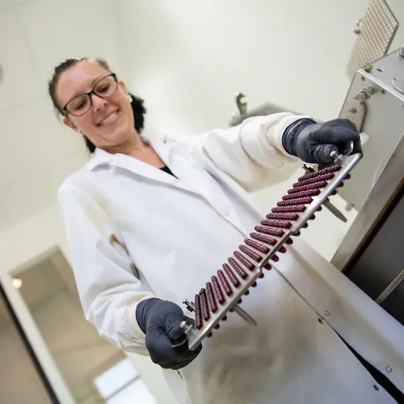 Laboratory professional handling a rack of test samples